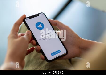 CHIANG MAI, THAÏLANDE - APR 11, 2021: Femme main tenant iPhone X avec le service de réseau social Telegram sur l'écran. IPhone 10 a été créé et Banque D'Images
