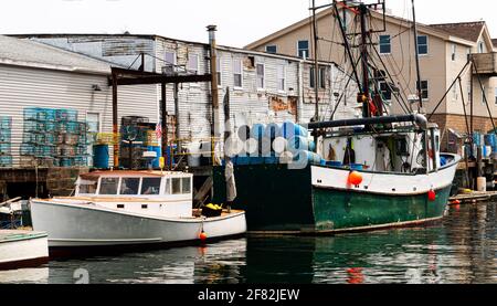 Bateaux de pêche commerciaux amarrés derrière des bâtiments avec des pièges à homard colorés, corde et tout ce dont ils ont besoin pour être prêts à retourner à la mer le prochain Banque D'Images