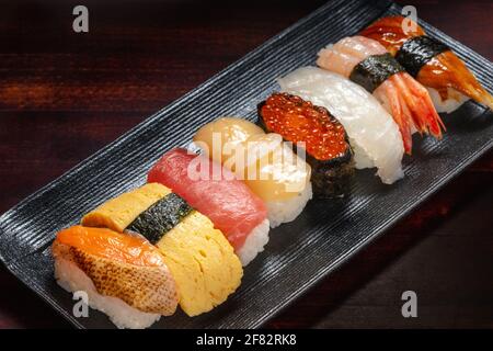 Décor de petits pains à sushis avec caviar et poisson frais haché sur fond, cuisine asiatique, cuisine japonaise traditionnelle Banque D'Images