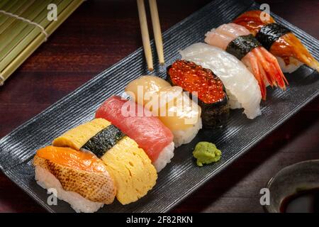 Décor de style japonais composé de petits pains à sushis avec caviar et poisson frais haché sur l'assiette, plats asiatiques et plats japonais traditionnels Banque D'Images