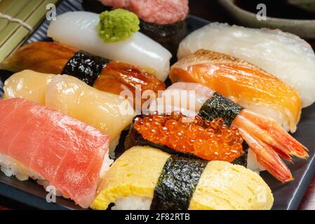 Décor de style japonais composé de petits pains à sushis avec caviar et poisson frais haché sur l'assiette, plats asiatiques et plats japonais traditionnels Banque D'Images