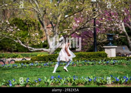 Une jeune fille afro-américaine vêtue de ses plus belles Pâques traverse les jardins du château Smithsonian à Washington Banque D'Images