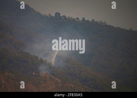 Katmandou, Népal. 11 avril 2021. Un hélicoptère de la compagnie Simrik Airlines serra un feu de forêt qui a flambé le long de la forêt de Shivapuri à Katmandou, au Népal, le dimanche 11 avril 2021. Wildfire au Népal Credit: Skanda Gautam/ZUMA Wire/Alamy Live News Banque D'Images