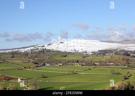 Middleton-in-Teesdale, Teesdale, comté de Durham, Royaume-Uni. 11 avril 2021. Météo Royaume-Uni. Les fortes averses de neige au-dessus de Middleton-in-Teesdale laissent une ligne de démarcation abruptes entre l'hiver dans les collines et les conditions printanières dans la vallée. Crédit : David Forster/Alamy Live News Banque D'Images