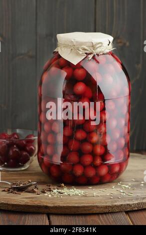 Cerises sucrées compotées compote en conserve dans un pot en verre libre de plastique sur fond de garde-manger rustique en bois, gros plan, solution de stockage des aliments, fruits et légumes en conserve, chauve-souris Banque D'Images