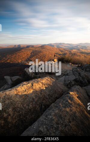 Un randonneur qui prend la vue au lever du soleil sur le parc national de Shenandoah pendant une journée de fin d'automne. Banque D'Images