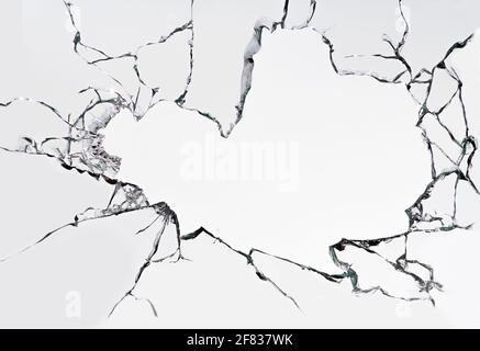 Verre cassé fissuré sur fond blanc. La texture de la fenêtre est endommagée. Banque D'Images