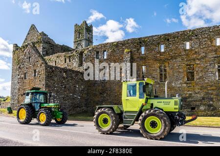 Timoleague, West Cork, Irlande. 11 avril 2021. Deux tracteurs d'époque passent devant le Franciscan Friary dans le village de Timoleague à l'ouest de Cork lors d'une belle journée ensoleillée. Les tracteurs, UNE Mercedes MB Trac 1100 de 1990 et une John Deere 2850 de 1992 sont la propriété des agriculteurs David DeEasy et Paudie O'Leary, qui vivent tous deux à Timoleague. Crédit : AG News/Alay Live News Banque D'Images