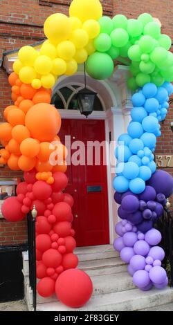 Alors que les restrictions de verrouillage se terminent le 12 mai 2021, une entreprise locale orne sa porte d'entrée avec des balons colorés pour accueillir les clients de retour. Banque D'Images