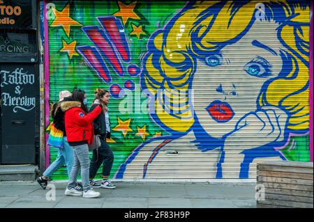 Londres, Royaume-Uni. 11 avril 2021. Nouveaux graffitis sur les magasins fermés - Camden Lock est bondé à la veille de la prochaine étape de l'assouplissement des restrictions de coronavirus, permettant à la vente au détail non essentielle de rouvrir. Peu de gens portent des masques comme ils sont à l'extérieur, mais la distanciation sociale est devenue une chose du passé. Crédit : Guy Bell/Alay Live News Banque D'Images