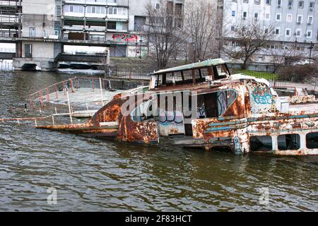 Vieux navire en contrebas rouillé dans l'eau sur le territoire du port de la rivière. Vieux bateau en contrebas sur la rivière. Banque D'Images