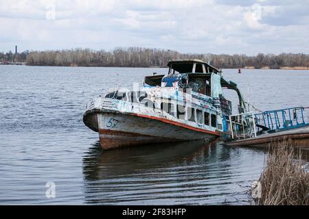 Vieux navire en contrebas rouillé dans l'eau sur le territoire du port de la rivière. Vieux bateau en contrebas sur la rivière. Banque D'Images