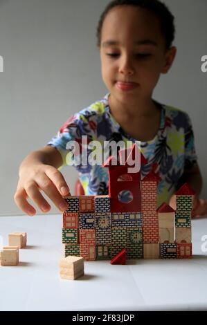 salvador, bahia, brésil - 24 janvier 2021 : un enfant jouant avec un bloc de bois de construction pour enfants dans la ville de Salvador. Banque D'Images