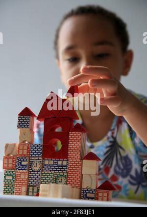 salvador, bahia, brésil - 24 janvier 2021 : un enfant jouant avec un bloc de bois de construction pour enfants dans la ville de Salvador. Banque D'Images