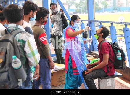 (210411) -- BANGALORE, 11 avril 2021 (Xinhua) -- UN agent de santé recueille des échantillons auprès des passagers pour un test de réaction en chaîne de la polymérase (RT-PCR) à une station de bus, à Bangalore, Inde, avril 11, 2021. (STR/Xinhua) Banque D'Images