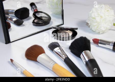 Durée de vie des brosses de maquillage, du rouge à lèvres, du miroir et de la fleur de tissu en arrière-plan Banque D'Images