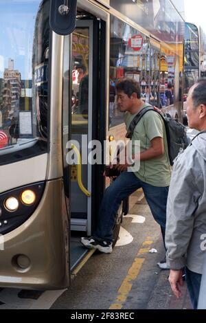 Scène de rue à Hong Kong avec un homme à bord d'un bus KMB À Tsim Sha Tsui Kowloon Banque D'Images