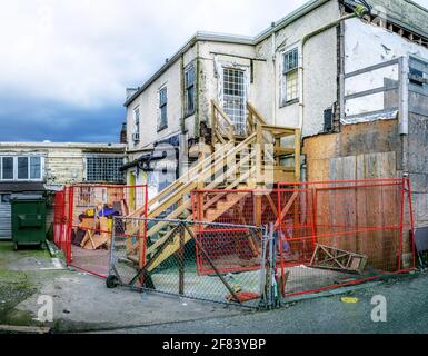 Bâtiment abandonné en réparation. Clôturé dans la maison de 2 étages pas à la hauteur du code du bâtiment et dangereux. Cour en purée avec peinture écaillée des murs extérieurs a Banque D'Images