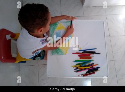 salvador, bahia / brésil - 18 novembre 2020: L'enfant est vu peindre un dessin du drapeau du Brésil pendant les activités scolaires. Banque D'Images