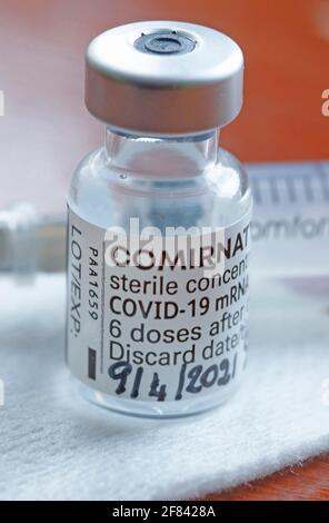 Gênes, Italie -avril 2021, Comirnaty, vaccin ARN contre le covid-19, développé par Pfizer BioNTech sur fond rouge Banque D'Images