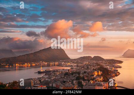 Alesund, Norvège. Ciel spectaculaire et naturel aux couleurs rouges au-dessus des îles d'Alesund au coucher du soleil. Fond ciel coloré. Beauté en N Banque D'Images