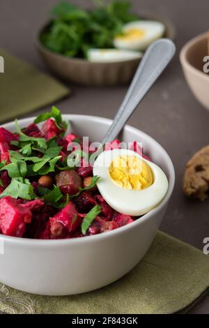 Vinaigrette russe à salade dans des assiettes avec œufs durs et pain noir, salade de légumes durs et marinés et pois verts en conserve Banque D'Images