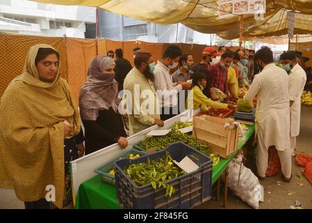 Lahore, Pakistan. 11 avril 2021. Les Pakistanais achètent de la farine, des sachets de sucre, des fruits et des légumes à des taux de contrôle auprès de Ramzan Sasta Bazar, dans la ville de Shalamar, dans le cadre du programme de secours du Ramadan organisé par le gouvernement provincial avant le mois Saint des musulmans de Ramzan-ul-mubarak à Lahore. (Photo de Rana Sajid Hussain/Pacific Press) Credit: Pacific Press Media production Corp./Alay Live News Banque D'Images