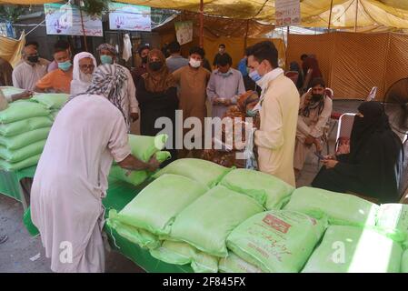 Lahore, Pakistan. 11 avril 2021. Les Pakistanais achètent de la farine, des sachets de sucre, des fruits et des légumes à des taux de contrôle auprès de Ramzan Sasta Bazar, dans la ville de Shalamar, dans le cadre du programme de secours du Ramadan organisé par le gouvernement provincial avant le mois Saint des musulmans de Ramzan-ul-mubarak à Lahore. (Photo de Rana Sajid Hussain/Pacific Press) Credit: Pacific Press Media production Corp./Alay Live News Banque D'Images