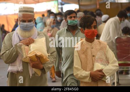 Lahore, Pakistan. 11 avril 2021. Les Pakistanais achètent de la farine, des sachets de sucre, des fruits et des légumes à des taux de contrôle auprès de Ramzan Sasta Bazar, dans la ville de Shalamar, dans le cadre du programme de secours du Ramadan organisé par le gouvernement provincial avant le mois Saint des musulmans de Ramzan-ul-mubarak à Lahore. (Photo de Rana Sajid Hussain/Pacific Press) Credit: Pacific Press Media production Corp./Alay Live News Banque D'Images