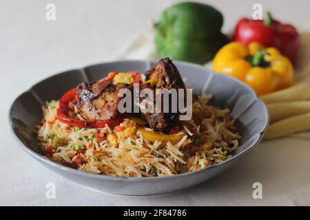 Riz frit aux légumes maison servi avec du poulet frite sec. Prise de vue sur fond blanc Banque D'Images