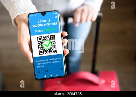 Passeport de vaccination COVID-19 dans un téléphone portable pour les voyages, le touriste tient un smartphone avec application de certificat de santé, passe numérique du coronavirus. Concept de c Banque D'Images