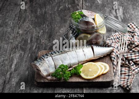 Maquereau en saumure avec citron et épices dans un pot en verre sur une table en bois Banque D'Images