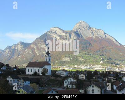 Le village de Wangs avec l'église Saint-Antoine dans le canton de Saint-Gall, Sarganserland avec l'impressionnant Gonzen en arrière-plan dans la soirée. Banque D'Images