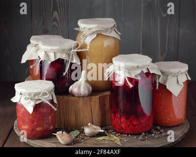 Variété de légumes en conserve: Betterave conservée, pâte de tomate, haricots conservés, confiture, cornichons sur fond rustique en bois, fruits en conserve, économie l Banque D'Images