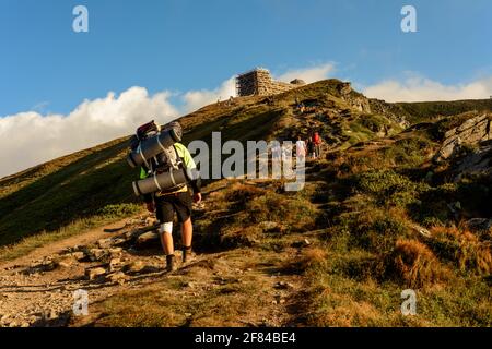 Un jeune homme descend du haut de la montagne PIP Ivan, observe les paysages épiques autour de la montagne, porte un grand sac à dos de randonnée.2020 Banque D'Images