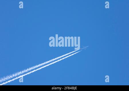 Avion avec des sentiers de condensation dans le ciel bleu, Allemagne Banque D'Images