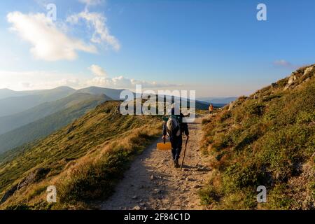 Trois jeunes touristes, deux petits garçons et un adolescent marchent sur les sentiers de la crête monténégrine, autour du sommet des montagnes carpates.2020 Banque D'Images