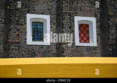 Vitraux avec garniture blanche sur le mur ocre et en pierre du couvent espagnol de style colonial San Gabriel à San Pedro Cholula Puebla Mexico. Banque D'Images