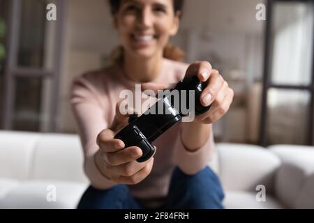 Femme latine émotive assise sur un canapé relaxant jouant à la télévision jeu Banque D'Images