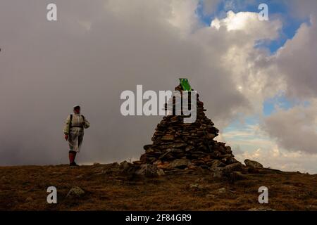 Les touristes en imperméable se tiennent sur le sommet de la montagne, le Mont Bebeneskul et le brouillard, les nuages de pluie sur la crête monténégrine, les touristes heureux.2020 Banque D'Images