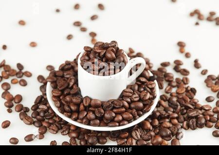Tasse à café avec grains sur une assiette fermée Banque D'Images