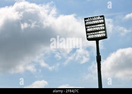 Le mât du projecteur est allumé devant le ciel bleu avec des nuages, Bochum, Allemagne Banque D'Images