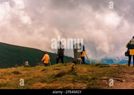 Les touristes suivent un sentier de montagne sur un panneau touristique à la destination suivante.2020 Banque D'Images