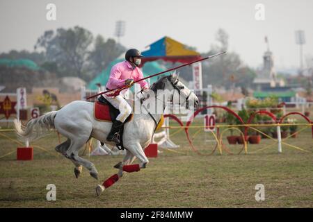 Un soldat népalais se charge de l'équitation lors du festival de course hippique « Ghodejatra ». Le 'Ghode Jatra' est un festival annuel de chevaux célébré sur le terrain de Cavalry au Népal à Katmandou, qui marque la défaite d'un démon hindou. Banque D'Images