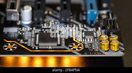 Carte de circuit imprimé sur les détails de la carte mère de l'ordinateur moderne. Composants électroniques. Micro-puces, condensateurs, résistances. LA LED s'allume sur fond noir. Banque D'Images