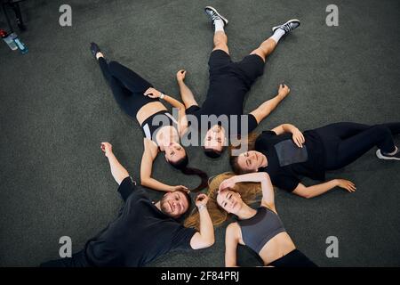 Mettez les gens en forme avec des vêtements de sport qui se posent sur le sol de la salle de sport Banque D'Images