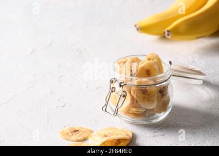 Tranches de fruits croustilles de banane sur fond clair, séchage à la maison. Sucre végétalien gratuit. Gros plan Banque D'Images