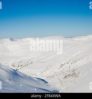 Vue sur les sommets et les rochers couverts de neige les nuages sous le ciel bleu Banque D'Images