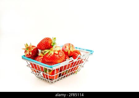 Panier d'épicerie avec fraises sur fond blanc isolé. Le concept de shopping en ligne sur l'Internet fruits frais et baies. Banque D'Images