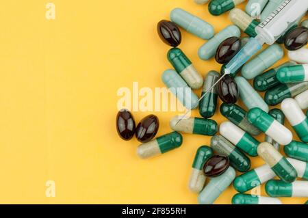 Assortiment de comprimés colorés, pilules, médicaments sur fond jaune. Concept de la pharmacie, des personnes et de la santé. Copier l'espace. Banque D'Images